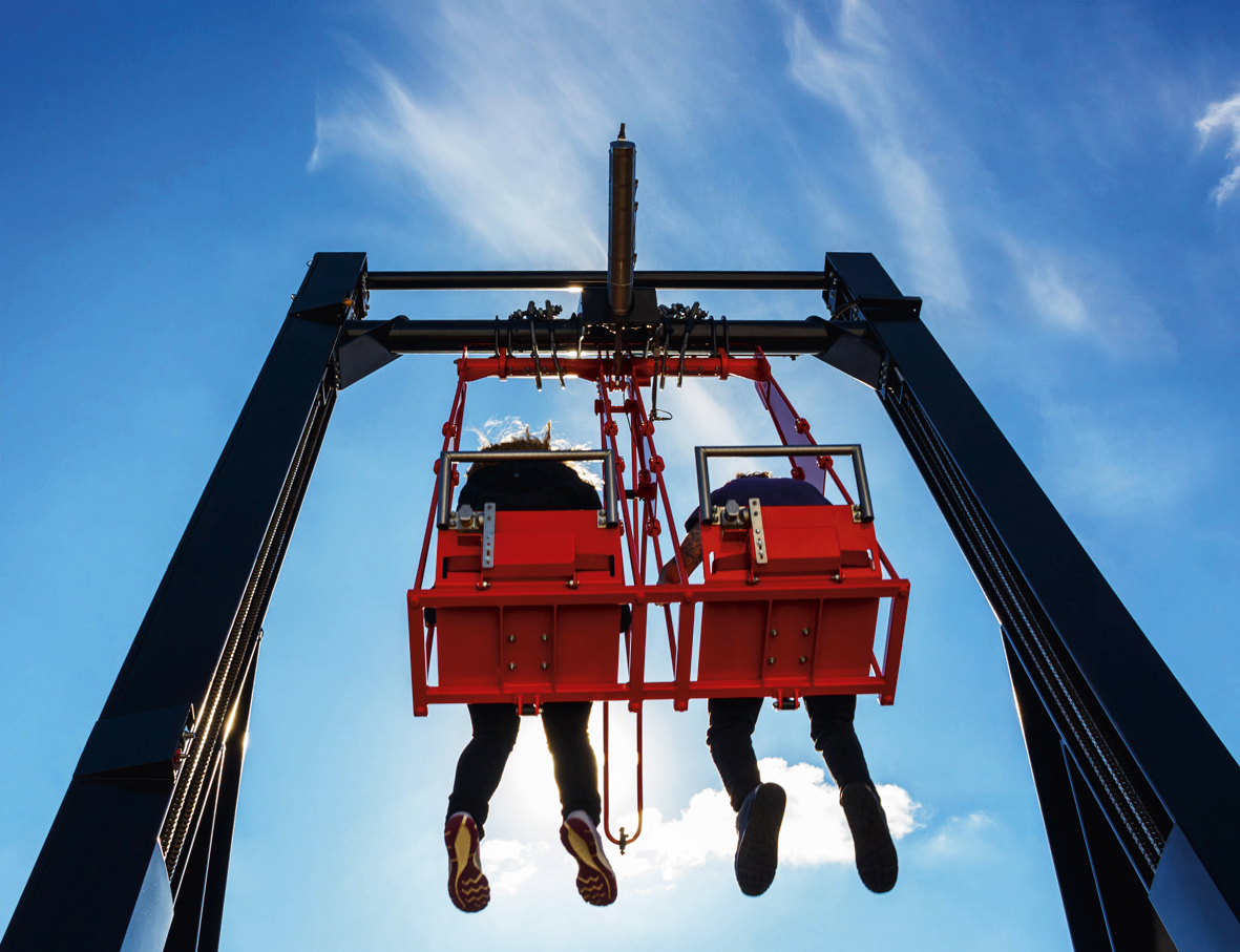 75804679 - pair having fun in swing on a high building against blue sky
